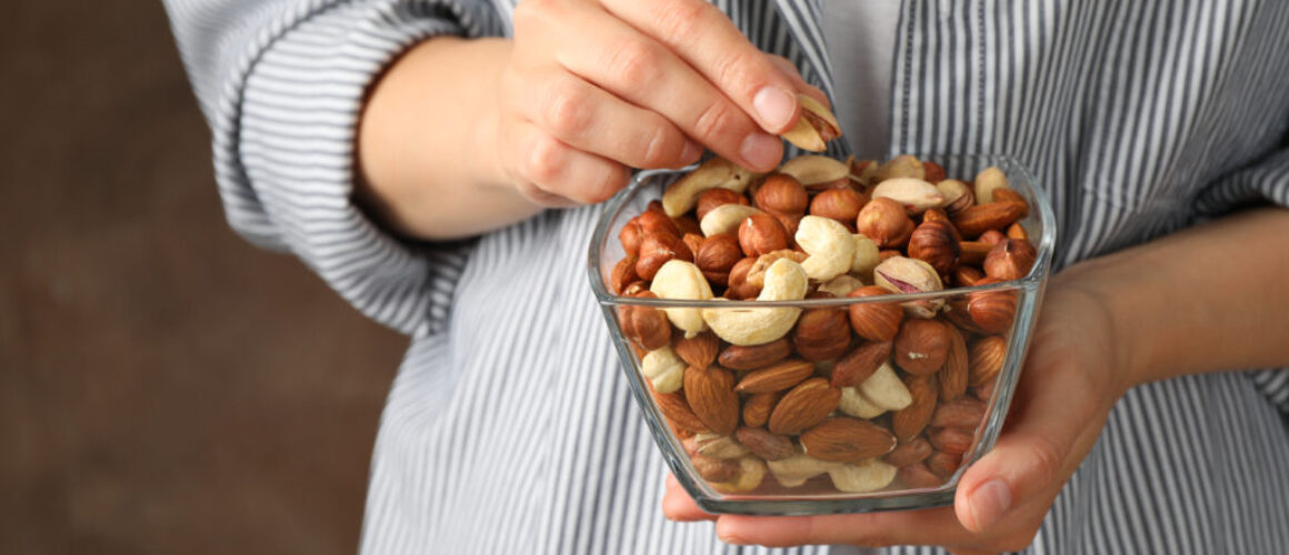 Woman hold bowl with different nuts. Healthy eating